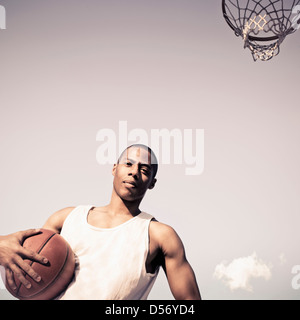 African American man holding basketball on court Banque D'Images