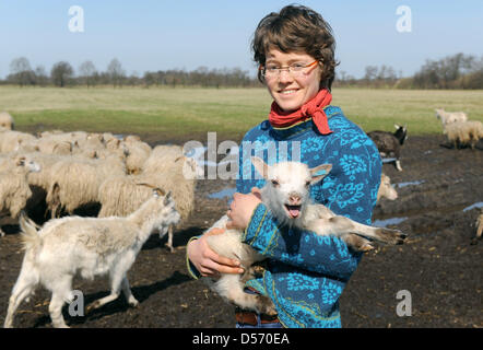 Sophie Berger sourit avec un agneau près de Tannenhausen, Allemagne, 02 avril 2010. Le troupeau de blanc-duc d'Heath, un vieux et les espèces rares, a donné naissance à 44 agneaux. Photo : Ingo Wagner Banque D'Images