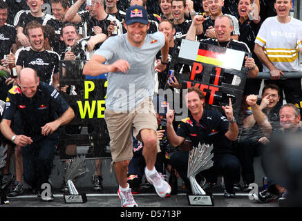 Australian pilote de Formule 1 Mark Webber (avant) s'exécute à partir d'une douche de champagne pour son coéquipier Sebastian Vettel victorieux (couverte) de Red Bull à côté de Red Bull Christian Horner team principal avant (3-R) après le Grand Prix de Formule 1 de Malaisie à Sepang racetrack près de Kuala Lumpur, Malaisie, 04 avril 2010. Vettel a remporté la course devant son coéquipier australien Mark Webber et Banque D'Images