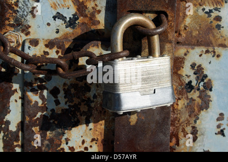 Verrouillage du fer et de la chaîne sur une vieille porte rouillée. Banque D'Images