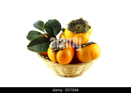 Ensemble de feuilles de persimmon fruit avec panier de paille. Banque D'Images