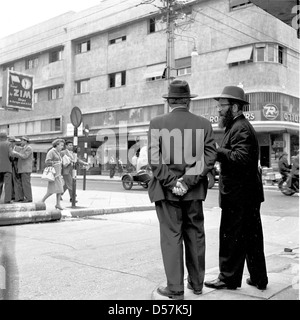 Israël, années 1950. Tableau historique des deux hommes juifs israéliens bien habillé de parler ensemble dans la rue. Banque D'Images