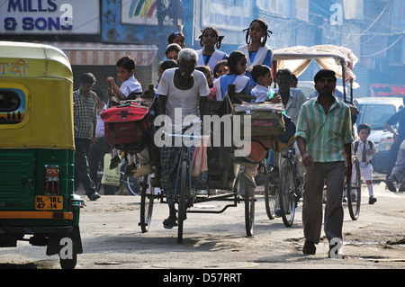 Rickshaw Man d'emmener les enfants à l'école le matin à New Delhi Banque D'Images