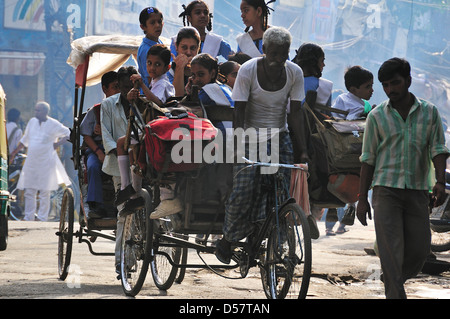 Rickshaw Man d'emmener les enfants à l'école le matin à New Delhi Banque D'Images