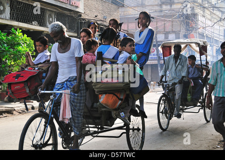 Rickshaw Man d'emmener les enfants à l'école le matin à New Delhi Banque D'Images