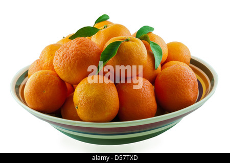 Mandarines mûres juteuses avec des feuilles vertes dans un bol en céramique color Banque D'Images