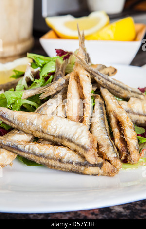 Une plaque d'anchois frits au citron et salade Banque D'Images