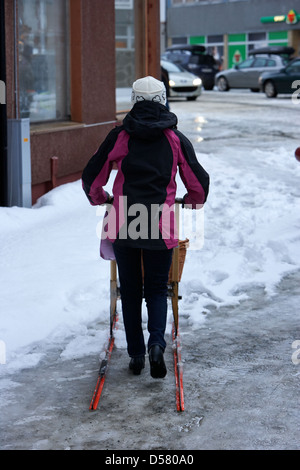 Woman kick out shopping sur traîneau couvert de glace principale rue commerçante storgata finnmark Honningsvag Norvège europe Banque D'Images