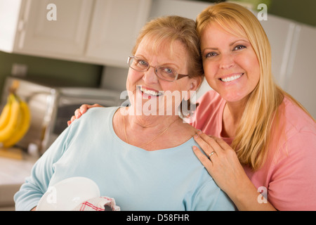 Young Adult Woman and Young Daughter au lavabo de cuisine. Banque D'Images