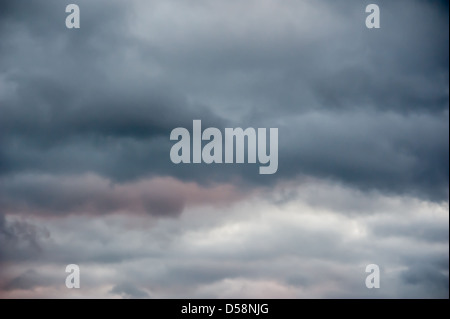 Les nuages orageux peeking through lumière dans un ciel sombre. Banque D'Images