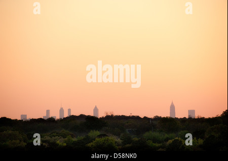 L'Atlanta skyline baignée dans la lueur orange du coucher du soleil au-dessus de boisés comme vu de Stone Mountain Park. Banque D'Images