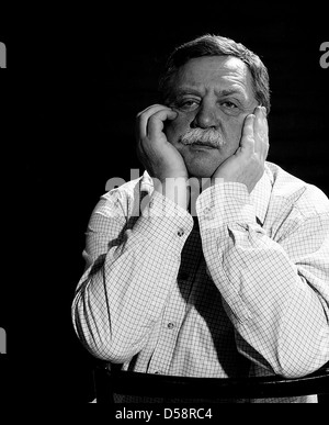 Le noir et blanc portrait of handsome middle-aged man soutenir la tête avec sa main Banque D'Images