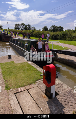 Barge / narrowboat entrant dans l'écluse sur une journée bien remplie à Foxton Locks, Grand Union Canal, Market Harborough, Leicestershire, Angleterre, ROYAUME-UNI Banque D'Images