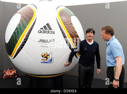 Joachim Loew (L), l'entraîneur-chef de l'équipe nationale de football allemande, et entraîneur de gardien Andreas Koepke debout à côté d'une immense réplique de la Coupe du Monde FIFA 2010 officiel match ball "Jabulani" lors d'une conférence de presse de la Fédération allemande de football (DFB) dans Eppan, Italie, 28 mai 2010. L'équipe d'Allemagne se prépare pour la prochaine Coupe du Monde FIFA 2010 en Afrique du Sud dans un train Banque D'Images