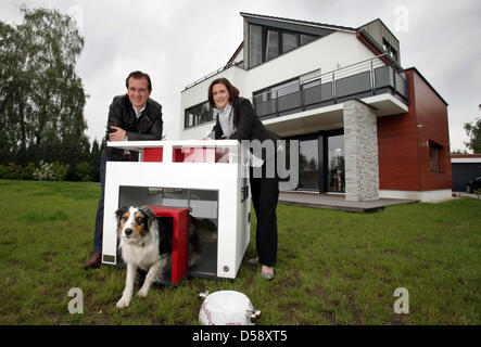 Andre Heinermann et Doria Keppler administration dog utility company 'Best Friends Home' et de chien posent Mara à côté du chien de luxe maison de type 'Cubix' en face de l'entreprise siège à Paderborn, Allemagne, 27 mai 2010. Best Friends 'Accueil' propose des chambres de luxe pour chiens. Photo : Oliver Krato Banque D'Images