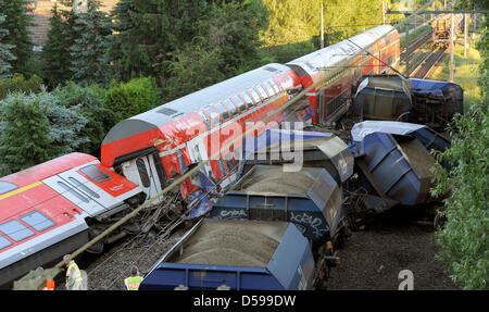 Les entraîneurs et les wagons renversés d'un train régional de voyageurs (L) et un train de marchandises à une ligne de chemin de fer dans Peine, Allemagne, 17 juin 2010. 16 personnes ont été blessées lorsque les deux trains s'est écrasé dans l'autre le 16 juin 2010. Le train de marchandises a déraillé dans la ligne droite, ligne ferroviaire entre Hanovre et Braunschweig et couru dans le train de voyageurs. Photo : Holger Hollemann Banque D'Images