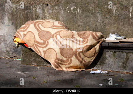 Sans-abri endormi sur le banc de parc à Naples Italie Banque D'Images