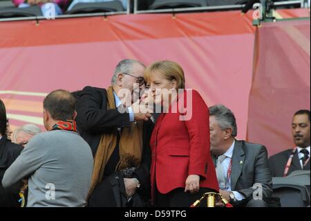 La chancelière allemande, Angela Merkel (CDU) parle avec un homme non identifié avant la Coupe du Monde 2010 match quart entre l'Argentine et l'Allemagne à la Green Point Stadium de Cape Town, Afrique du Sud 03 juillet 2010. L'Allemagne a gagné 4-0. Photo : Marcus Brandt dpa - veuillez vous reporter à http://dpaq.de/FIFA-WM2010-TC Banque D'Images