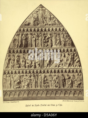 Le tympanum du portail nord de la cathédrale de Cologne en Allemagne, avec des sculptures détaillées représentant des scènes religieuses, qui font partie du patrimoine architectural de l’église. Banque D'Images