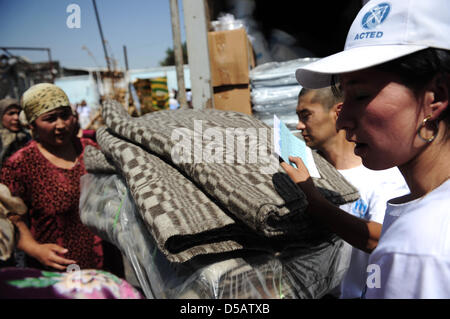 Les organisations de secours distribuent des couvertures, des bidons d'eau et d'autres fournitures de secours dans un quartier résidentiel à Osh, Kirghizistan, 16 juillet 2010. Le pays a été secoué par des perturbations. Le ministre des Affaires étrangères allemand Guido Westerwelle visites pays d'Asie centrale. Photo : HANNIBAL HANSCHKE Banque D'Images