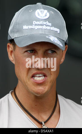 Formule 1 allemande racedriver Michael Schumacher (Mercedes GP) parle à un mécanicien à son garage à l'Hockenheimring à Hockenheim, Allemagne, 22 juillet 2010. Photo : Jens Buettner Banque D'Images