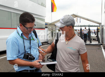 Formule 1 allemande racedriver Michael Schumacher (Mercedes GP) signe un autographe pour un ventilateur à l'enclos à Hockenheim, Allemagne, 22 juillet 2010. Photo : Roland Weihrauch Banque D'Images