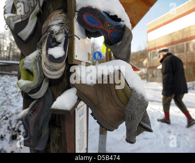 Usé des chaussures de randonnée de la campagne précédente, "l'hiver" à un poteau de signalisation sur le "zéro km" de la 168.3Km de long 'chemin de randonnée Rennsteig'-à Blankenstein, Allemagne, 05 janvier 2010. La réunion de haut niveau entre l'Hoerschel Blankenstein et près de Eisenach atteint un prix de l'Association de randonnée allemand (Kassel) pour être un sentier de randonnée de qualité de l'Allemagne en juin 2008, après plusieurs una Banque D'Images