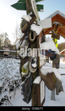 Usé des chaussures de randonnée de la campagne précédente, "l'hiver" à un poteau de signalisation sur le "zéro km" de la 168.3Km de long 'chemin de randonnée Rennsteig'-à Blankenstein, Allemagne, 05 janvier 2010. La réunion de haut niveau entre l'Hoerschel Blankenstein et près de Eisenach atteint un prix de l'Association de randonnée allemand (Kassel) pour être un sentier de randonnée de qualité de l'Allemagne en juin 2008, après plusieurs una Banque D'Images