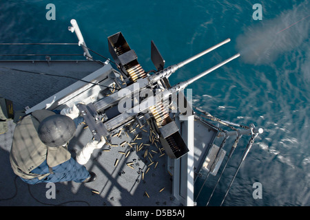 Un marin de l'US Navy avec feux de mitrailleuses de calibre .50 pendant un exercice d'entraînement à bord du navire d'assaut amphibie USS Boxer le 26 mars 2013, au large de la côte de Californie du Sud. Banque D'Images