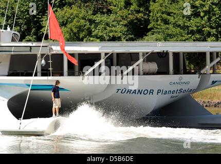 Un membre d'équipage se trouve sur l'arrière du plus grand navire à énergie solaire Turanor Planet Solar' 'au départ de Kiel, Allemagne, 07 août 2010. Le catamaran à énergie solaire a quitté le port et se dirige vers tgeh Méditerranée pour un voyage d'essai. Un voyage autour du monde est schedueled pour démontrer les possibilités d'énergies renouvelables. Photo : Carsten Rehder Banque D'Images