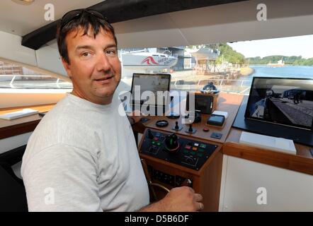 Steffen Mueller, directeur général de chantiers Knierim et capitaine du plus grand navire à énergie solaire, sourires sur le pont de 'Turanor Planet Solar' avant de partir de Kiel, Allemagne, 07 août 2010. Le catamaran à énergie solaire a quitté le port et se dirige vers tgeh Méditerranée pour un voyage d'essai. Un voyage autour du monde est schedueled pour démontrer les possibilités Banque D'Images