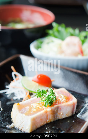 Recherche rapide avec Sashimi grillé sauce épicée servi avec légumes frais sur une assiette, une cuisine de style japonais Banque D'Images