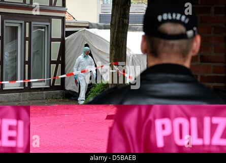 Un policier fixe le site de découverte d'un vieux de cinq ans garçon mort dans le district de Dellingen (Holzminden), alors qu'un enquêteur de la criminalité laisse une tente, Allemagne, 18 août 2010. Le cadavre a été retrouvé dans un garage à côté de la maison de la mère. L'enfant de cinq ans a disparu depuis le mardi après-midi (17 août). Photo : Jochen Luebke Banque D'Images