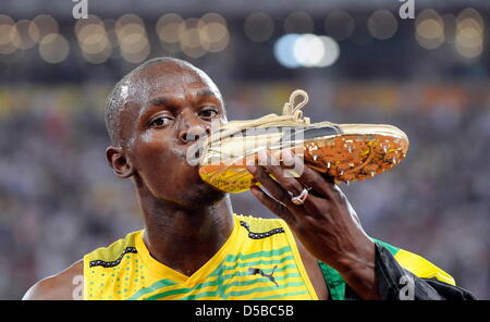 (Dossier) - Un fichier photo datée du 16 août 2008 comprend le sprinter jamaïcain Usain Bolt comme il embrasse sa chaussure pendant les Jeux Olympiques d'été à Beijing, en Chine. Boulon est maintenant le meilleur coureur payé comme son matériel compagnie Puma a annoncé le renouvellement du contrat avec la superstar jamaïcaine jusqu'en 2013 le 24 août 2010. Photo : Gero Breloer Banque D'Images