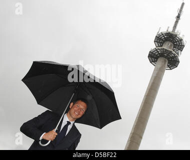 Deutsche Telekom CHEF Rene Obermann passe devant un émetteur mât avec un parapluie à Kyritz, Allemagne, 30 août 2010. Telekom vient de mettre une station de quatrième génération LTE en exploitation en Kyritz. Photo : Britta Pedersen Banque D'Images