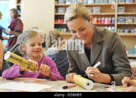 L'épouse de président fédéral allemand Christian Wulff travaille sur un kaléidoscope selfmade, avec les enfants lors de sa visite au programme des manuels dans le "open studio" du Centre Paul Klee à Berne, Suisse, 8 septembre 2010. Le studio propose des cours de l'atelier de formation professionnelle pour les étudiants de l'écoles et foyers. Rossfeld Centre d'enfants et les visiteurs sont invités à sta Banque D'Images