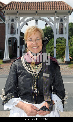 Un guide en costume traditionnel pose devant une porte ornée de Jork, Allemagne, 03 août 2010. En raison de la destruction de la DEUXIÈME GUERRE MONDIALE, il n'y a que 14 portes traditionnelles telles la gauche dans la région de l'Altes Land de Basse-Saxe. Photo : Ingo Wagner Banque D'Images