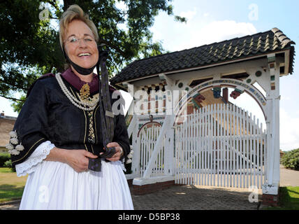 Un guide en costume traditionnel pose devant une porte ornée de Jork, Allemagne, 03 août 2010. En raison de la destruction de la DEUXIÈME GUERRE MONDIALE, il n'y a que 14 portes traditionnelles telles la gauche dans la région de l'Altes Land de Basse-Saxe. Photo : Ingo Wagner Banque D'Images