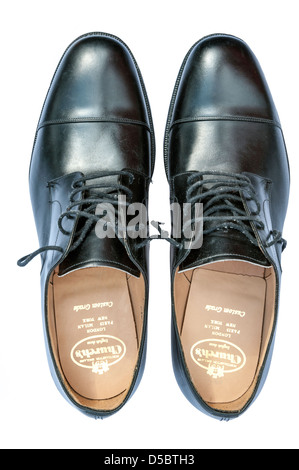 Scruffy brogues chaussures pour hommes découper sur un fond blanc. Noir de l'Eglise officielle d'usure dentelle paire de chaussures en cuir,UK. Banque D'Images