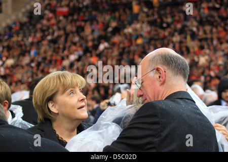 Angela Merkel rbert Lammert célébrer la messe du Pape Benoît XVI au stade olympique portant des manteaux de pluie - Berlin, Allemagne Banque D'Images