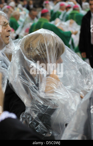 Angela Merkel Norbert Lammert célébrer la messe du Pape Benoît XVI au stade olympique portant des manteaux de pluie. Berlin, Allemagne Banque D'Images