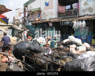 Les gens se rassemblent les ordures dans le bidonville de Tondo Manille, Philippines, janvier 2010. Dans un atelier en Tondo, les gens faire des bijoux et sacs de déchets jetés. Environ 30 familles d'améliorer leurs revenus et conditions de vie en vendant leurs produits qui sont en demande d'articles de mode à Londres.Photo : Christiane Oelrich Banque D'Images