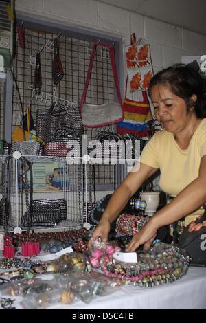 Une femme présente des colliers qui sont faites d'ordures de Manille, Philippines, janvier 2010. Dans un atelier en Tondo, les gens faire des bijoux et sacs de déchets jetés. Environ 30 familles d'améliorer leurs revenus et conditions de vie en vendant leurs produits qui sont en demande d'articles de mode à Londres.Photo : Christiane Oelrich Banque D'Images