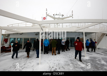 Passagers à pont ouvert d croisière arctique avec la neige couvrant la norvège europe Banque D'Images