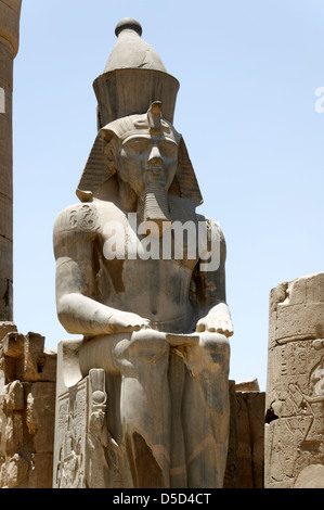 L'Égypte. Une colossale statue de Ramsès flancs l'entrée de la Grande Colonnade d'Amenhotep III au temple de Louxor. Banque D'Images