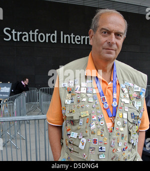 Un commerçant porte une veste couverte de badges pin à l'extérieur de la gare internationale de Stratford. . Parc olympique Banque D'Images