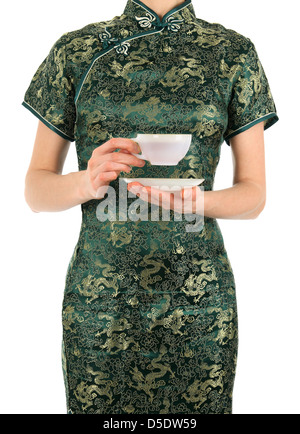 Femme en vert robe chinoise tenant une tasse de thé. Banque D'Images