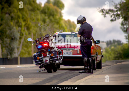 Une moto de police écrit un billet à un arrêt de la circulation dans l'Orange, CA. Banque D'Images