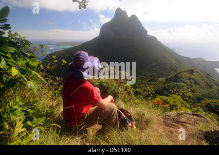 Female hiker resting à mi-chemin du Mont Gower, avec vue sur le mont Lidgbird, Lord Howe Island, Australie. Pas de monsieur Banque D'Images