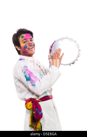 Man celebrating Holi avec jeu de tambourin Banque D'Images